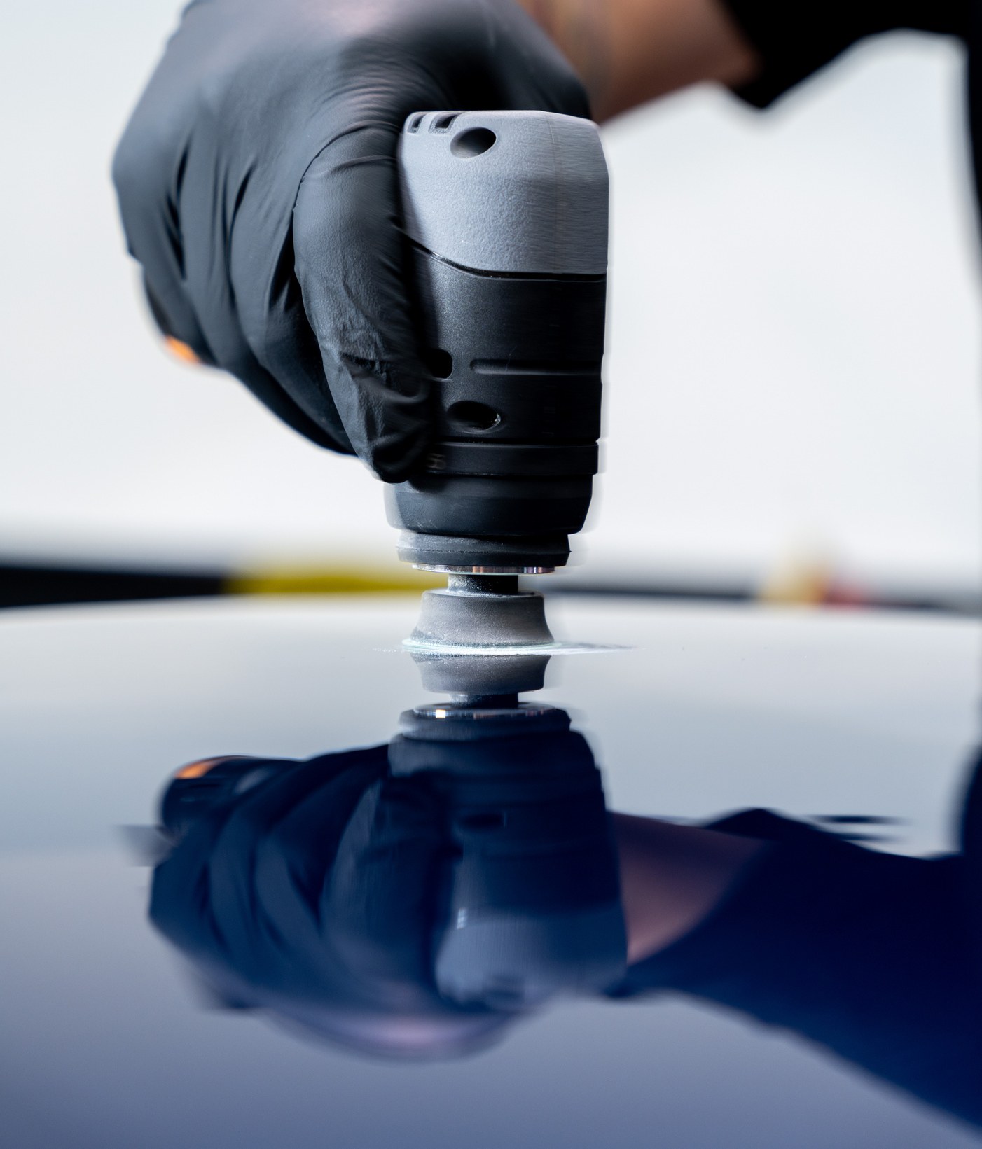 Orbital sander detail on a glossy painted surface